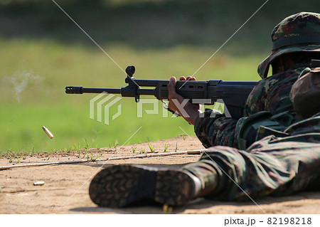 Soldier firing rifle gun to target 82198218