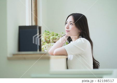 窓辺で物思いに耽る若い女性 82198517