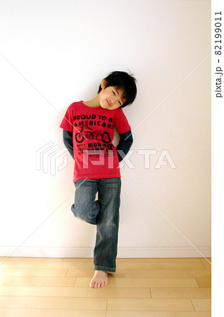 片足立ちをしてかわいいポーズをする男の子の写真素材