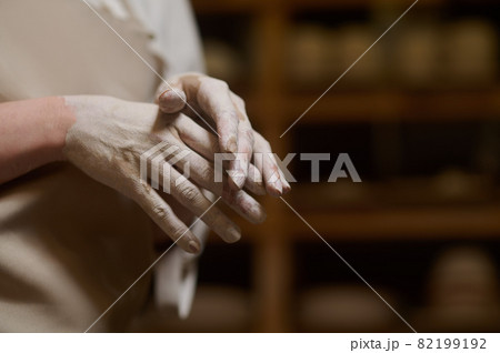 Close up of female potters hands in clay 82199192