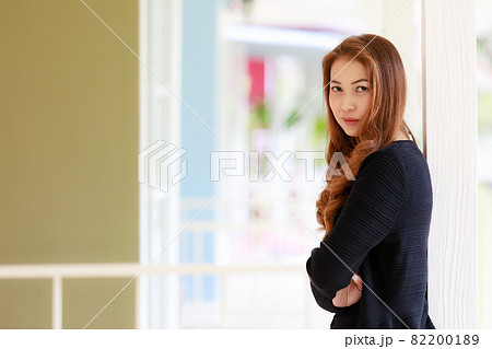 Portrait of long hair beautiful Asian woman in black sweater coat and blue jeans Portrait of long hair beautiful Asian woman in black sweater coat and blue jeans 82200189