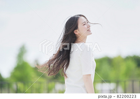 屋外で髪をなびかせる女性 82200223