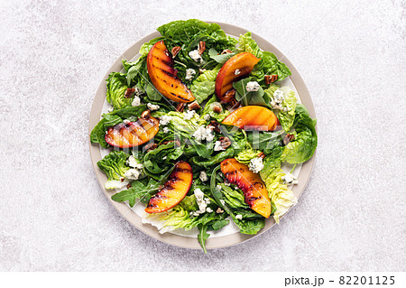 Salad with grilled peach, pecan nuts, blue cheese and arugula. 82201125