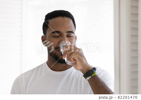 African man drinks still water, head shot portrait African man drinks still water, head shot portrait 82201470