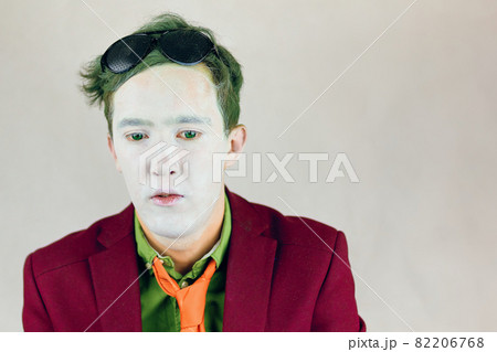 Actor with white makeup on face and green eyes and hair. Actor with white makeup on face and green eyes and hair. 82206768
