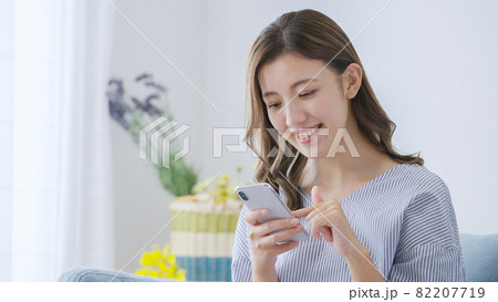 家でスマホを操作する若い女性 家でスマホを操作する若い女性 82207719