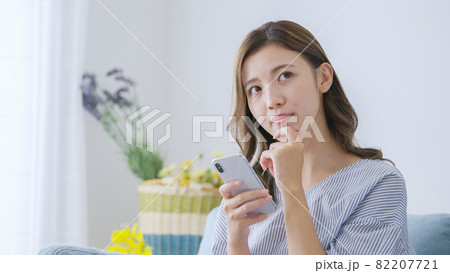 家でスマホを操作する若い女性 82207721