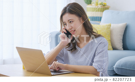 家でパソコンを操作する若い女性 82207723