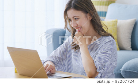 家でパソコンを操作する若い女性 家でパソコンを操作する若い女性 82207724