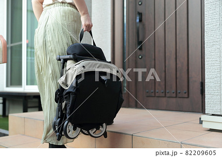 ベビーカーを持ち上げて帰宅する主婦 82209605