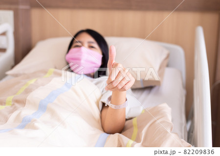 Patient Asian woman showing thumb up on sick bed at the hospital,Health insurance concept 82209836