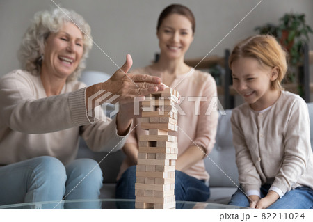 Happy three generations family playing boardgame at home. Happy three generations family playing boardgame at home. 82211024