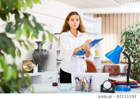 Confident young secretary takes important notes on a tablet in a office Confident young secretary takes important notes on a tablet in a office 82211193
