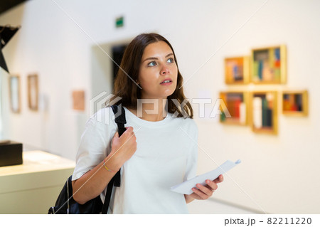 Thoughtful young girl in an art gallery studies works of art Thoughtful young girl in an art gallery studies works of art 82211220