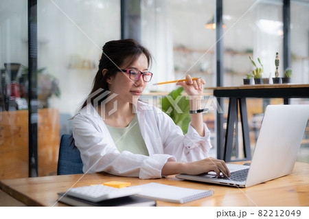 Young undergraduate student studying online class by laptop computer. 82212049