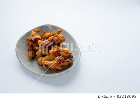 信楽焼の皿に盛り付けた鶏の手羽元の照り焼き 信楽焼の皿に盛り付けた鶏の手羽元の照り焼き 82213098