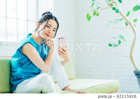 リビングでスマホを見る若い女性 リビングでスマホを見る若い女性 82215826