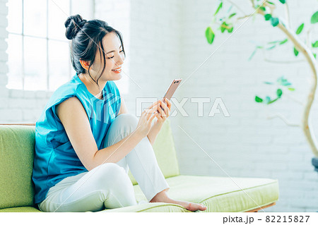 リビングでスマホを見る若い女性 リビングでスマホを見る若い女性 82215827