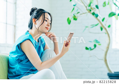 リビングでスマホを見る若い女性 リビングでスマホを見る若い女性 82215828