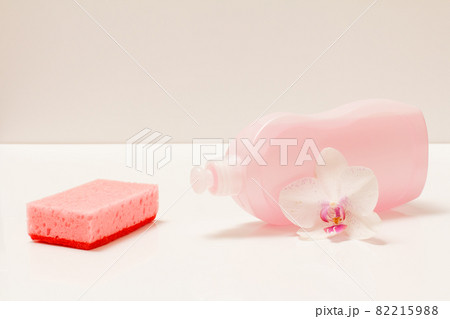 Bottle of dishwashing liquid and sponge on white background. 82215988