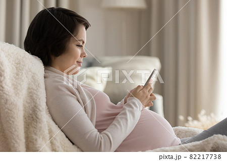 Expectant mom watch childbirth video on phone text message Expectant mom watch childbirth video on phone text message 82217738