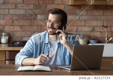 Smiling man in glasses talking on phone, consulting client Smiling man in glasses talking on phone, consulting client 82217754