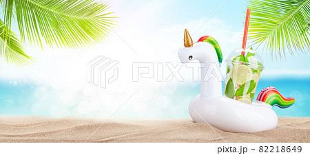 Fresh cold mojito cocktail in inflatable unicorn toy on tropical beach 82218649