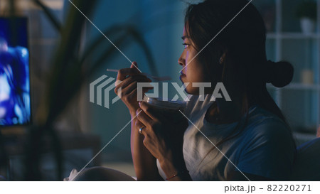 Asian woman eating and watching TV 82220271