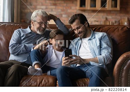 Happy three generations of men having fun with smartphone Happy three generations of men having fun with smartphone 82220814
