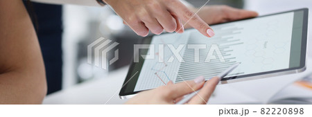 Employees study commercial indicators of business in form of graph on tablet 82220898
