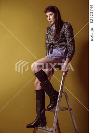 Mixed race sexy fashion model posing on stepladder. Mixed race sexy fashion model posing on stepladder. 82223744