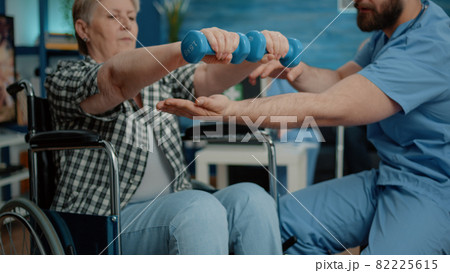 Close up of disabled woman using dumbbells for recovery Close up of disabled woman using dumbbells for recovery 82225615