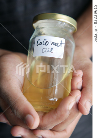 man hand hold a jar of coconut oil man hand hold a jar of coconut oil 82229615