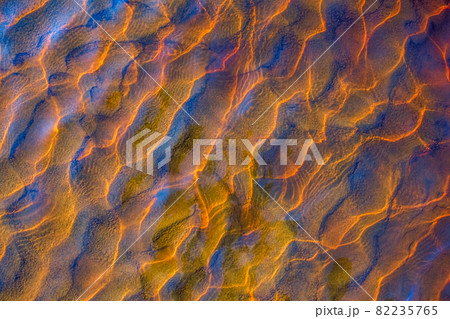 Clear golden water stream pattern with sand waves under it 82235765