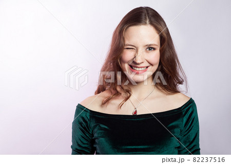Portrait of winky happy beautiful woman with freckles and classic green dress. 82237516