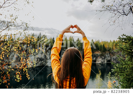 Marble canyon in Ruskeala, Karelia with girl who showing hand's heart over head Marble canyon in Ruskeala, Karelia with girl who showing hand's heart over head 82238905
