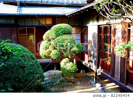 和室のある日本的な木造の和風家屋と整えられた松の木のある日本庭園の風景 82240454