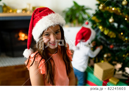 Happy caucasian girl wearing santa hat looking at camera at christmas time 82245603