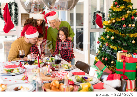 Caucasian multi generation family wearing santa hats looking at smartphone at christmas time 82245670