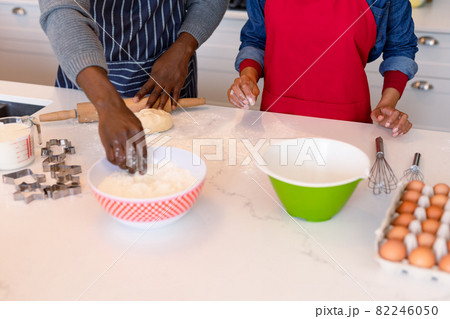 Midsection of african american couple wearing aprons, baking together Midsection of african american couple wearing aprons, baking together 82246050