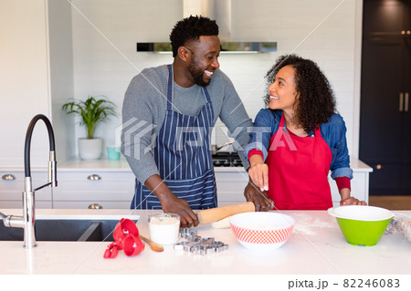 Happy african american couple wearing aprons, baking together 82246083