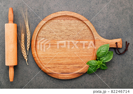 Empty wooden pizza platter set up on dark concrete. Pizza tray on dark concrete background flat lay and copy space. 82246714