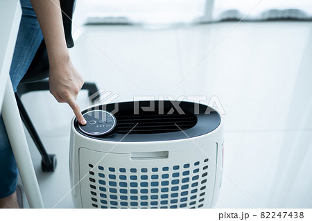 Woman using air purifier. Woman using air purifier. 82247438