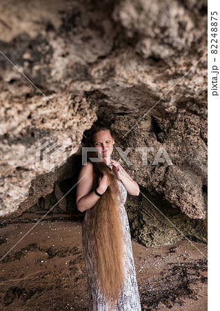 a woman on a rock looking into the distance against the sea a woman on a rock looking into the distance against the sea 82248875