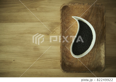 black sesame seeds on a white plate. Wooden table. Soft selective blurred background black sesame seeds on a white plate. Wooden table. Soft selective blurred background 82249922