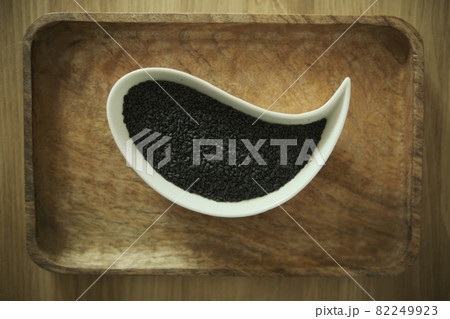 black sesame seeds on a white plate. Wooden table. Soft selective blurred background black sesame seeds on a white plate. Wooden table. Soft selective blurred background 82249923