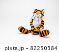 白い背景に座る可愛い虎の人形 82250384