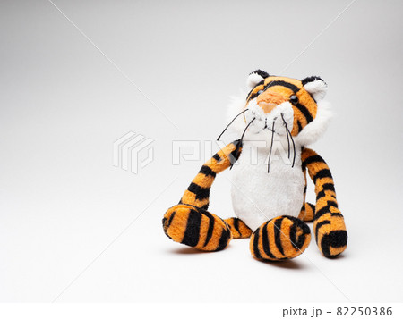 白い背景に座る可愛い虎の人形 82250386