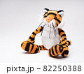 白い背景に座る可愛い虎の人形 82250388