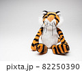 白い背景に座る可愛い虎の人形 82250390